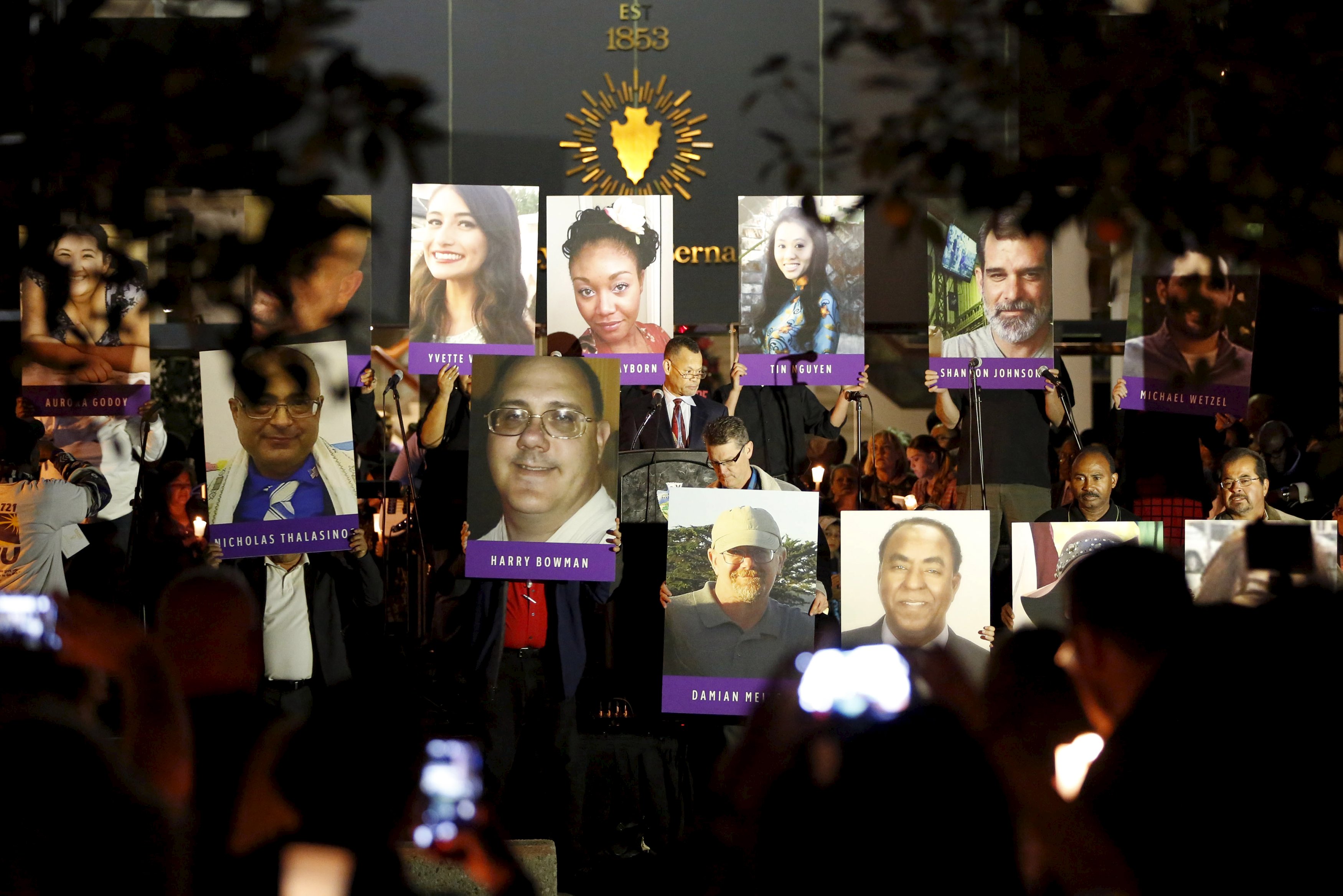 Posters of the 14 people killed in a Dec. 2 mass shooting at social services center in San Bernardino, Calif., are displayed during a Dec. 7 vigil in San Bernardino. (CNS/Reuters/Patrick T. Fallon)