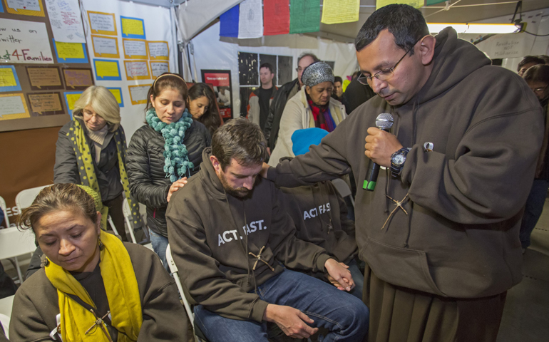 Franciscan Brother Juan Turios prays in 2013 with immigration reform advocates in Washington. (CNS/Jim West)