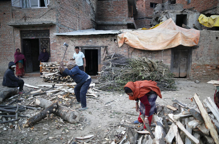 Nepalese who lost their home in the April 25 earthquake chop firewood in Lalitpur Dec. 21. (CNS/Narendra Shrestha, EPA)