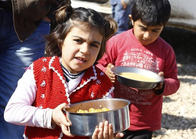 Kurdish refugee children from the Syrian town of Kobani carry food at a refugee camp in the border town of Suruc, Sanliurfa province, Feb. 1, 2015. (Reuters/Umit Bektas)