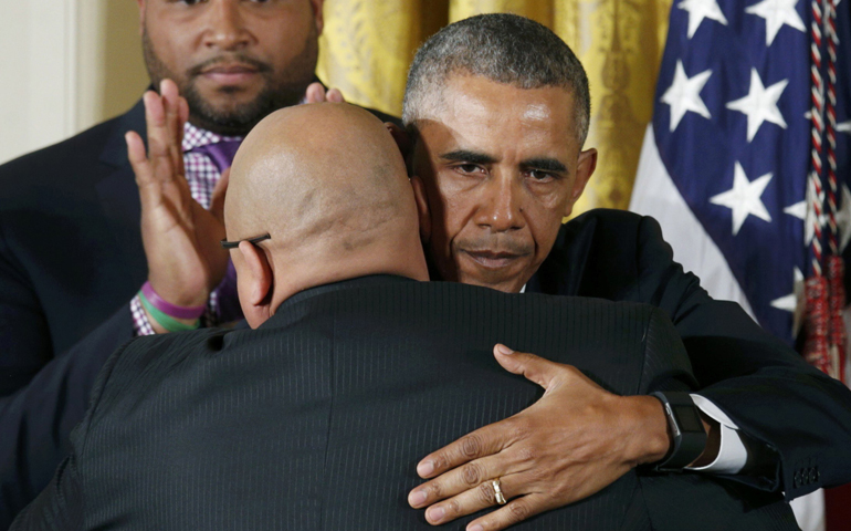 President Barack Obama hugs an unidentified man in the East Room of the White House in Washington Jan. 5 after announcing steps the administration is taking to reduce gun violence. (CNS/Kevin Lamarque, Reuters)