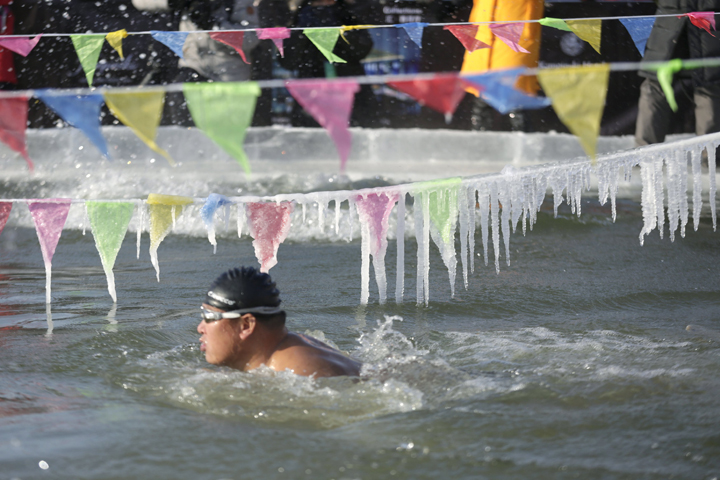 A swimmer competes in a pool carved from thick ice covering China's Songhua River during the Harbin Ice Swimming Competition in the northern city of Harbin, Heilongjiang province. (CNS/Aly Song, Reuters)