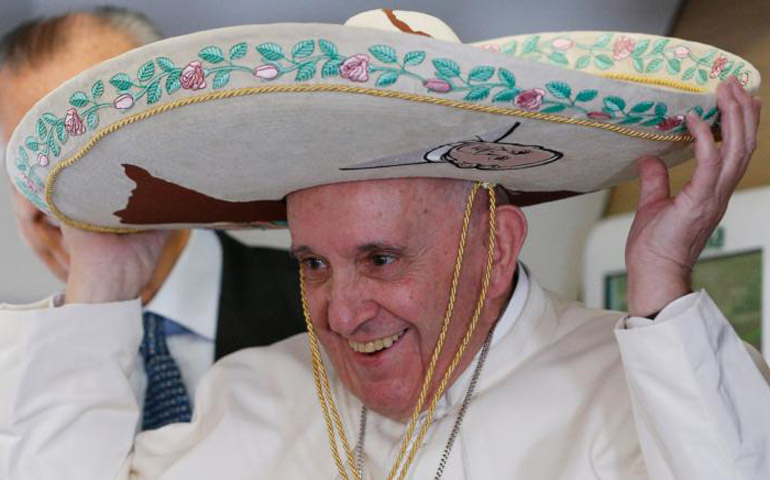 Pope Francis tries on a sombrero while meeting journalists aboard his flight to Havana Feb. 12. (CNS/Paul Haring)