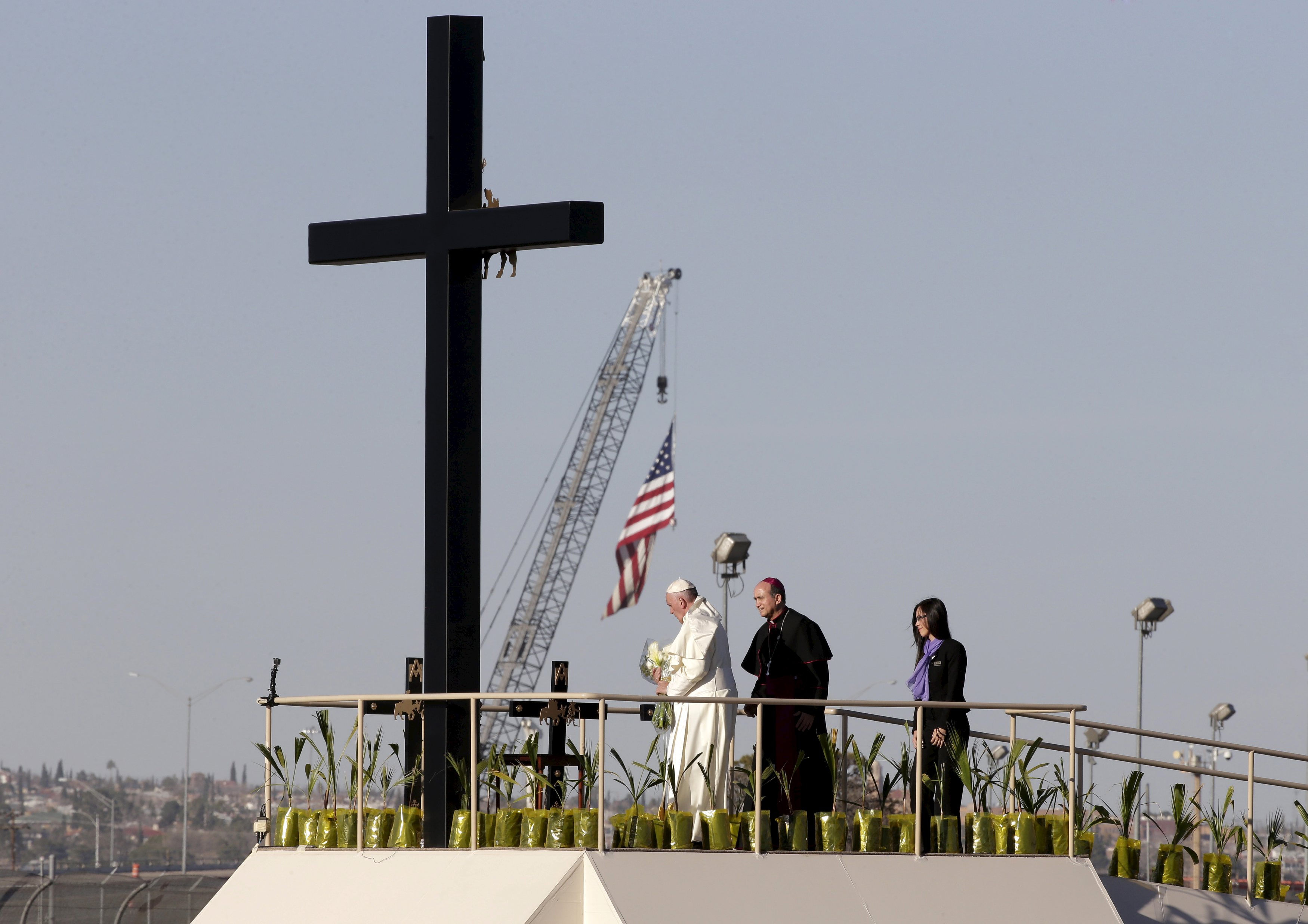 Pope Francis places flowers at a wooden cross at the border between Mexico and the U.S. in Ciudad Juarez, Mexico, Feb. 17. (CNS/Reuters/Max Rossi)