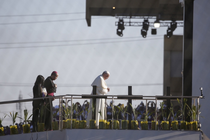 Pope Francis prays overlooking the U.S.-Mexico border before celebrating Mass Feb. 17 in Ciudad Juarez, Mexico. About 550 guests situated on a levee north of the Rio Grande in Texas took part in the Mass. (CNS photo/Nancy Wiechec) 
