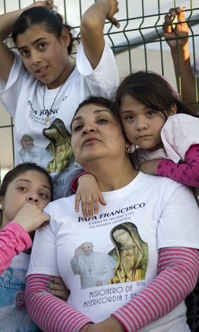 Laura Cecilia Hernández watches Pope Francis celebrate Mass Feb. 17 with her children and niece in Ciudad Juárez, Mexico. (CNS/David Maung)
