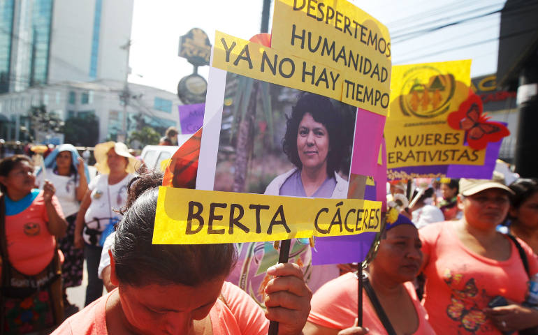 Activists hold a photo of slain environmental rights activist Berta Caceres during a protest outside the presidential house in Tegucigalpa, Honduras, March 8. (CNS photo/Jorge Cabrera, Reuters)