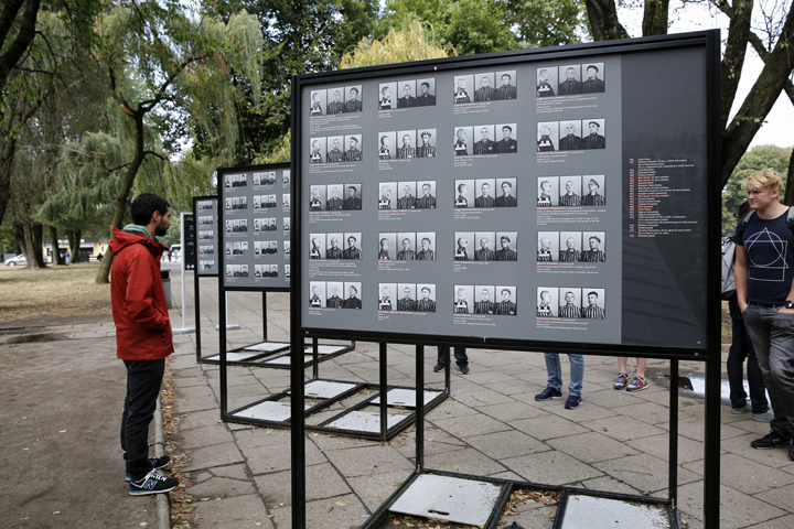 Visitors look over displays of photographs of concentration camp prisoners outside the Auschwitz-Birkenau Memorial and State Museum in Oswiecim, Poland, Sept. 4, 2015. (CNS/Nancy Wiechec)