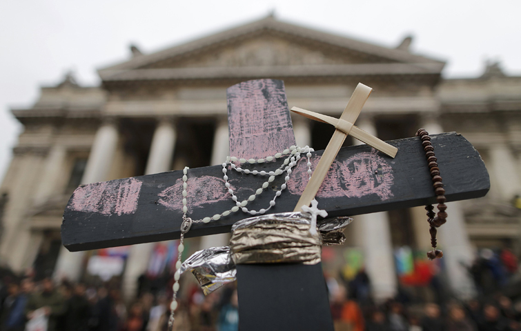 A cross with a rosary and prayer beads is seen March 23 at a makeshift memorial following bomb attacks the previous day in Brussels. (CNS/Christian Hartmann, Reuters)