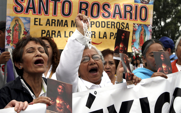 Women holding a rosary and images of Christ shout during a 2015 march for peace in Mexico City. (CNS/Reuters/Ginnette Riquelme)