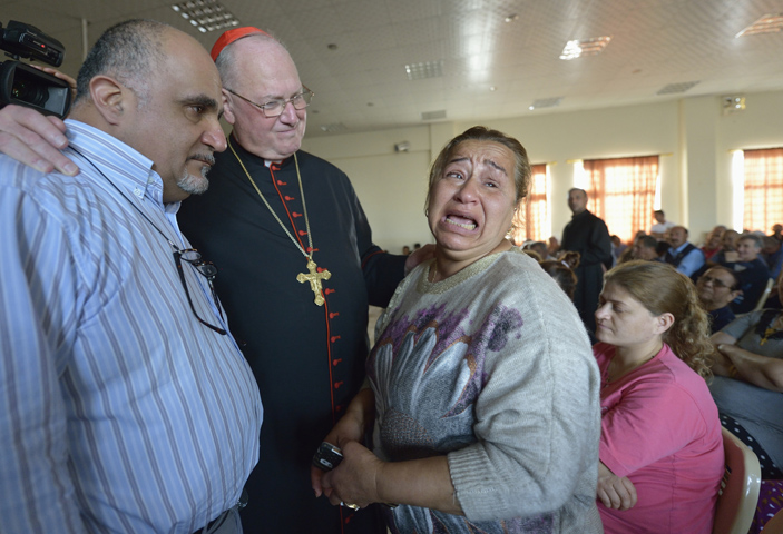 Cardinal Timothy Dolan listens to Amal Mare during a visit to a camp for internally displaced families in Ankawa, Iraq, April 9. (CNS/Paul Jeffrey)