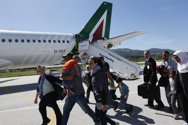 Refugees walk to board Pope Francis' plane to Rome at the international airport in Mytilene on the island of Lesbos, Greece, April 16, 2016. The pope brought 12 refugees to Italy aboard his flight. (CNS/Paul Haring)