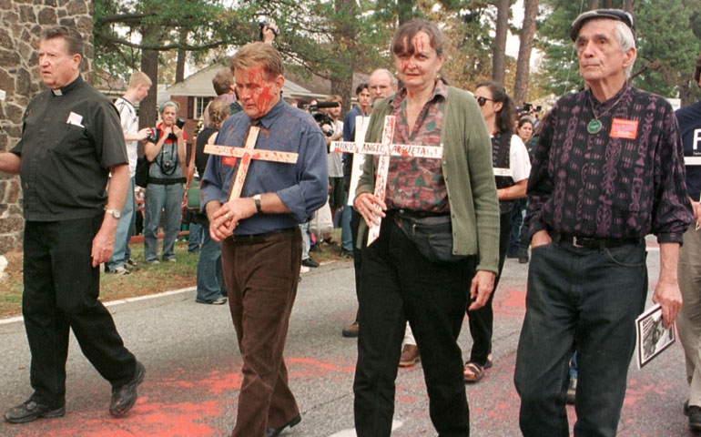Jesuit Fr. Daniel Berrigan, right, and actor Martin Sheen, third from right, join the annual School of the Americas protest in 1999 at Fort Benning, Ga. (CNS/Quirin, The Messenger)
