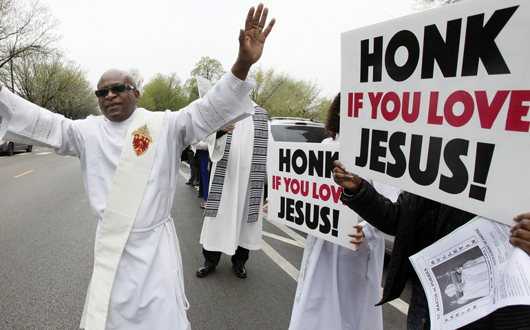 Deacon William Pouncy encourages drivers in passing cars to "Honk for Jesus" outside St. Martin de Porres Church in Chicago May 1. Parishioners took to the streets to witness for peace, after a Mass celebrated by Chicago Archbishop Blase Cupich. (CNS/Karen Callaway, Catholic New World)