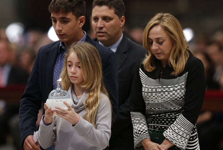 Members of the Pellegrino family walk forward to present a candle during a prayer vigil led by Pope Francis "to dry the tears" of the suffering in St. Peter's Basilica at the Vatican May 5. (CNS/Paul Haring) 