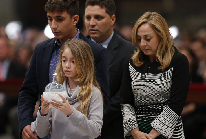 Members of the Pellegrino family walk forward to present a candle during a prayer vigil led by Pope Francis "to dry the tears" of the suffering in St. Peter's Basilica at the Vatican May 5. (CNS/Paul Haring)