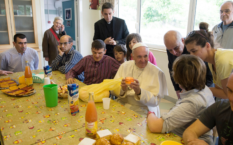 Pope Francis holds a candle as he visit the "Chicco" community, part of the L'Arche movement, in Ciampino, Italy, May 13. (CNS photo/L'Osservatore Romano)