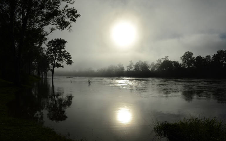 Early morning sun rises through the fog in 2013 over the swollen Brisbane River in Australia. (CNS photo/Dan Peled, EPA)