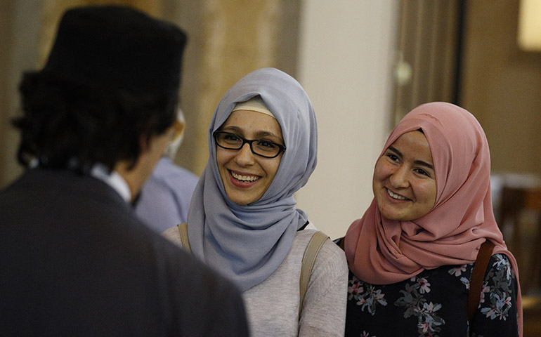Serife Demir and Sukriye Ozmen, who are Muslim students, chat with a guest after a prayer service in remembrance of the victims of the Orlando, Fla., terrorist attack at St. Patrick's Church in Rome June 16. The event was planned by the U.S. embassy to the Vatican in conjunction with the Santa Susanna Parish for U.S. Catholics in Rome. (CNS/Paul Haring)