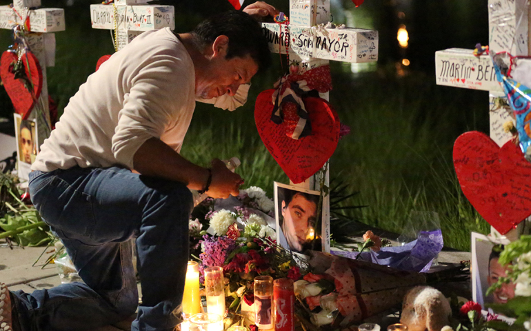 Jose Louis Morales cries as he kneels June 21 at a makeshift memorial for his brother Edward Sotomayor Jr. and other victims of the Pulse night club shootings in Orlando, Fla. (CNS/Carlo Allegri, Reuters)
