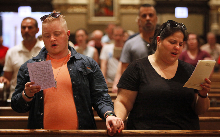 Jaeynes Childers and Maria Balata, members of the Chicago Archdiocesan Gay and Lesbian Outreach, hold hands at Our Lady of Mount Carmel Church June 19. (CNS/Karen Callaway, Catholic New World)