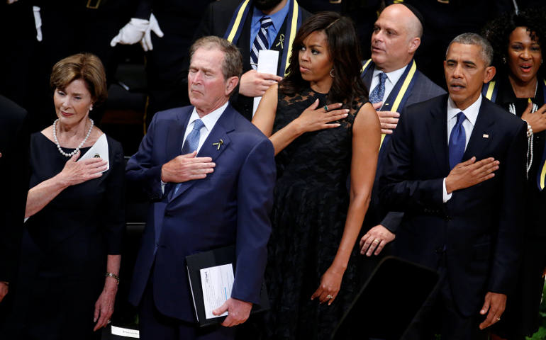 Former first lady Laura Bush, former U.S. President George W. Bush, first lady Michelle Obama and President Barack Obama hold their hands on their hearts as they sing the national anthem July 12 at a memorial service held in honor of police officers killed and wounded in shootings in Dallas. (CNS photo/Carlo Allegri, Reuters)