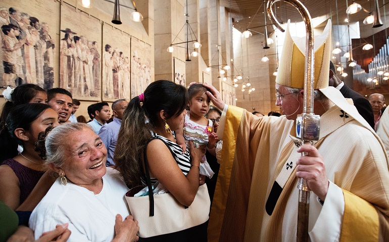 Archbishop José Gomez of Los Angeles blesses a girl during a special Mass celebrated July 17 in recognition of all immigrants at the Cathedral of Our Lady of the Angels in Los Angeles. (CNS/Vida Nueva/Victor Aleman)