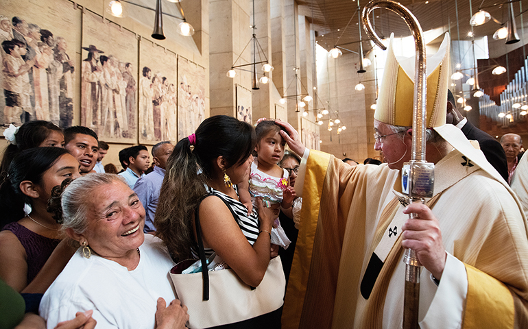 Archbishop José Gomez blesses a girl during a Mass celebrated July 17 in recognition of all immigrants at the Cathedral of Our Lady of the Angels in Los Angeles. (CNS/Vida Nueva/Victor Aleman)