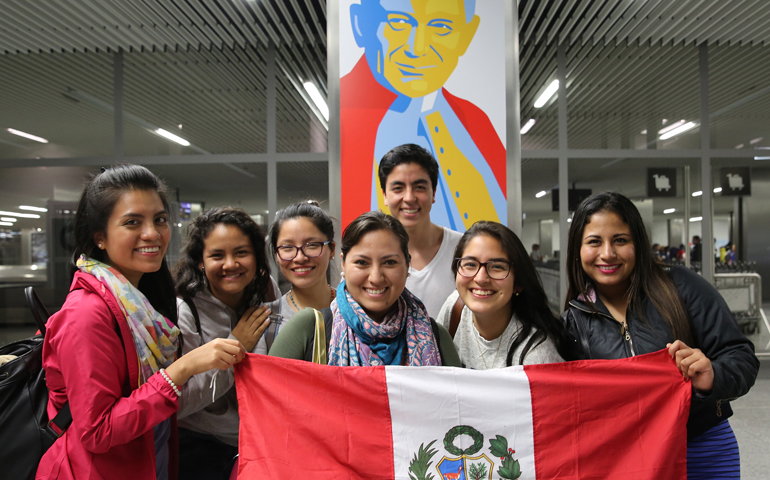 World Youth Day pilgrims from Lima, Peru, pose for a photo in front of an image of St. John Paul II after arriving July 23 at John Paul II International Airport in Krakow, Poland. (CNS/Bob Roller)