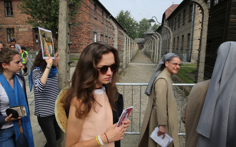 World Youth Day pilgrims walk past buildings during a July 25 visit to the Auschwitz former German Nazi concentration camp in Oswiecim, Poland. (CNS/Bob Roller)
