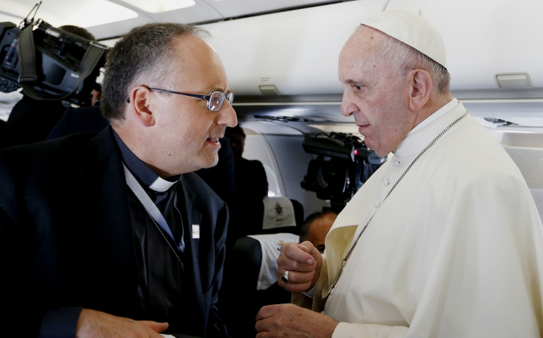 Pope Francis talks with Jesuit Fr. Antonio Spadaro, editor of La Civilta Cattolica, aboard a flight from Rome to Krakow, Poland, in 2016. (CNS/Paul Haring)