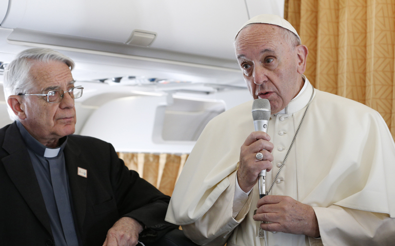 Pope Francis stands next to Jesuit Father Federico Lombardi, Vatican spokesman, as he speaks to journalists aboard his flight from Rome to Krakow, Poland, July 27. (CNS/Paul Haring)