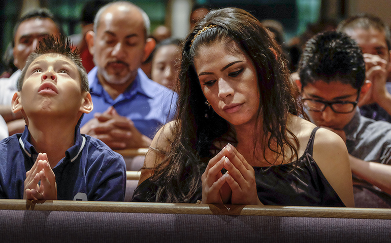Xavier Albarran, 9, and his mother, Erika Albarran, pray during the Litany of Saints at a Mass celebrated July 27 by Bishop David Choby of Nashville, Tenn., for the dedication of Sagrado Corazon Church at the Catholic Pastoral Center in Nashville. (CNS/Tennessee Register/Rick Musacchio)