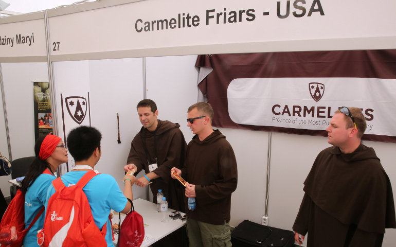 Carmelite Brs. Mike Joyce and Nate Michalak, both with the Chicago province, talk with pilgrims from Indonesia at the World Youth Day evangelization center July 29, 2016, in Krakow, Poland. (CNS/Bob Roller)