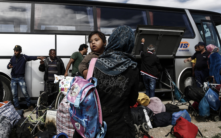 Syrian refugees stand outside a bus at a refugee camp near Idomeni, Greece, May 25. (CNS/Yannis Kolesidis, EPA)