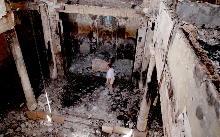 A man stands amid rubble inside St. John Church that was burned by mobs in 2013 near Cairo. Egypt's Catholic Church has welcomed a new law to facilitate the building of Christian places of worship. (CNS/EPA/Giro Mais) 