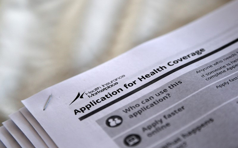 The federal government forms for applying for health coverage, seen at a 2013 rally in Jackson, Miss. (CNS/Jonathan Bachman, Reuters)