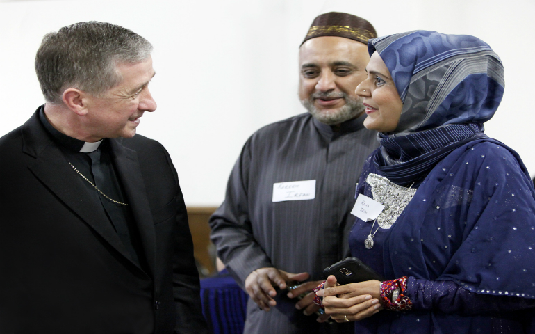 Chicago Archbishop Blase J. Cupich visits with a couple during a June 27 Catholic-Muslim dinner in Bridgeview, Ill. A Georgetown University research group found Catholic perceptions of Islam can tend to be negative or limited. (CNS photo/Karen Callaway/Catholic New World)