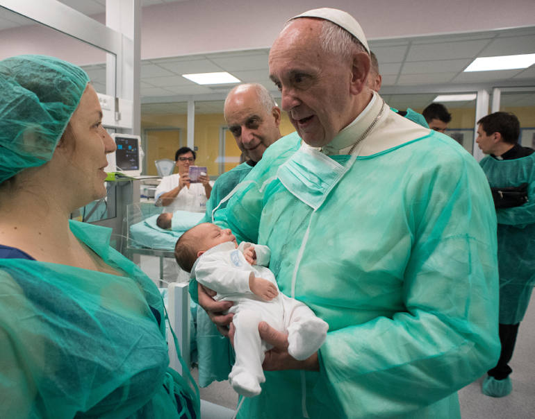 Pope Francis holds a baby as he visits the neonatal unit at San Giovanni Hospital in Rome Sept. 16. The visit was part of the pope's series of Friday works of mercy during the Holy Year. (CNS photos/L'Osservatore Romano, handout)