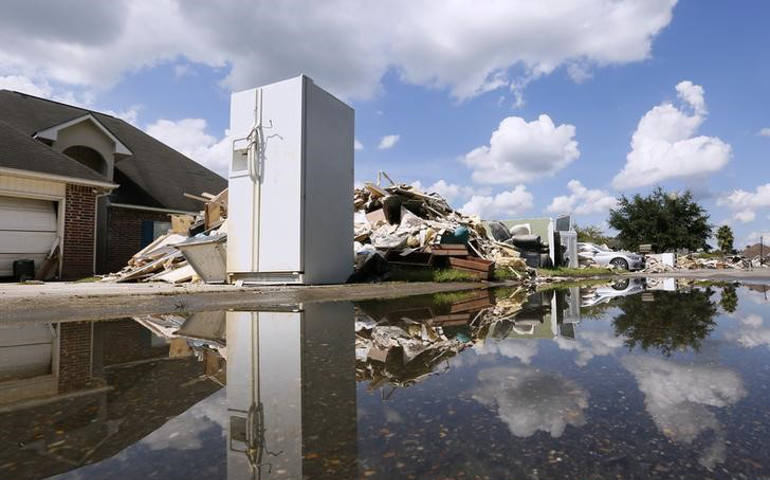 Piles of debris are left outside flood damaged homes Aug. 22 in Denham Springs, La. (CNS photo/Jonathan Bachman, Reuters)