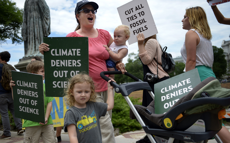 Protesters chant and display signs in front of the Smithsonian Castle during a 2015 anti-fossil fuel rally in Washington. (CNS/Shawn Thew, EPA)