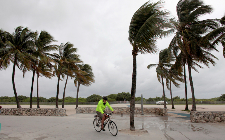A man rides his bicycle along the beach Oct. 6 prior to the arrival of Hurricane Matthew in Miami Beach. (CNS/Javier Galeano, Reuters)