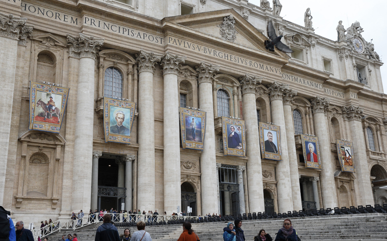 Tapestries showing seven soon-to-be-declared saints hang from the facade of St. Peter's Basilica at the Vatican Oct. 13.