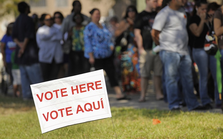 A sign in English and Spanish is seen as people wait to vote in 2012 outside a polling place in Kissimmee, Fla. (CNS/Scott A. Miller, Reuters)