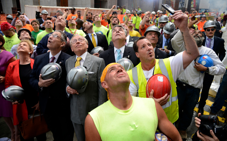 Developers and construction workers watch the final steel beam lifted to the top of 4 World Trade Center in New York City in this 2012 photo. President-elect Donald Trump credits blue-collar workers for his unexpected rise to the presidency of the United States. (CNS/EPA/Andrew Gombert)