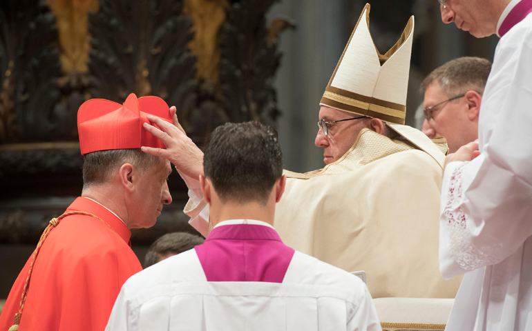 Pope Francis gives the red biretta to new Cardinal Blase Cupich of Chicago during a consistory at the Vatican Nov. 19. (CNS/L'Osservatore Romano via Reuters)