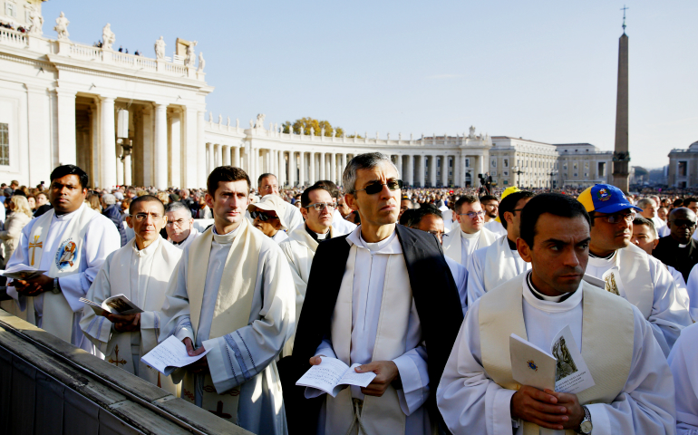 Priests watch a video monitor in St. Peter's Square as Pope Francis closes the Holy Door of St. Peter's Basilica prior to the closing Mass of the Year of Mercy at the Vatican Nov. 20, 2016. (CNS/Paul Haring)