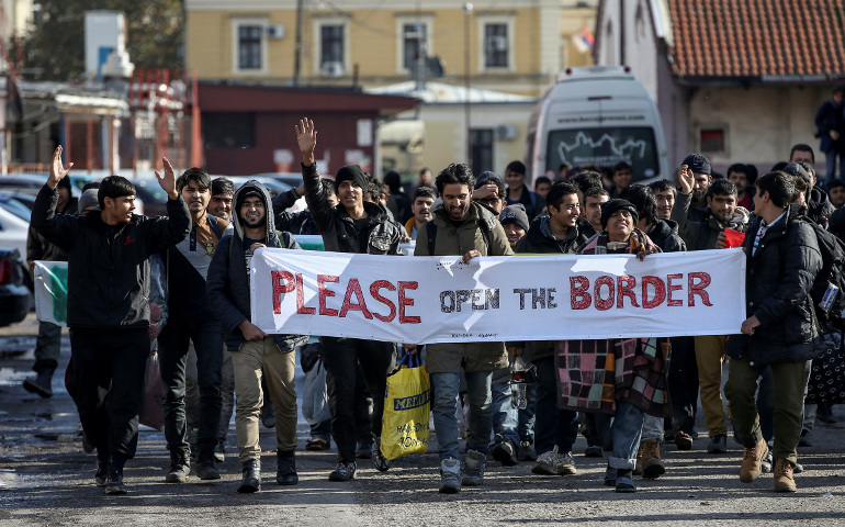 Refugees and migrants hold a banner and shout slogans Nov. 11 as they walk toward the Croatian border in Belgrade, Serbia. (CNS/Marko Djurica, Reuters) 