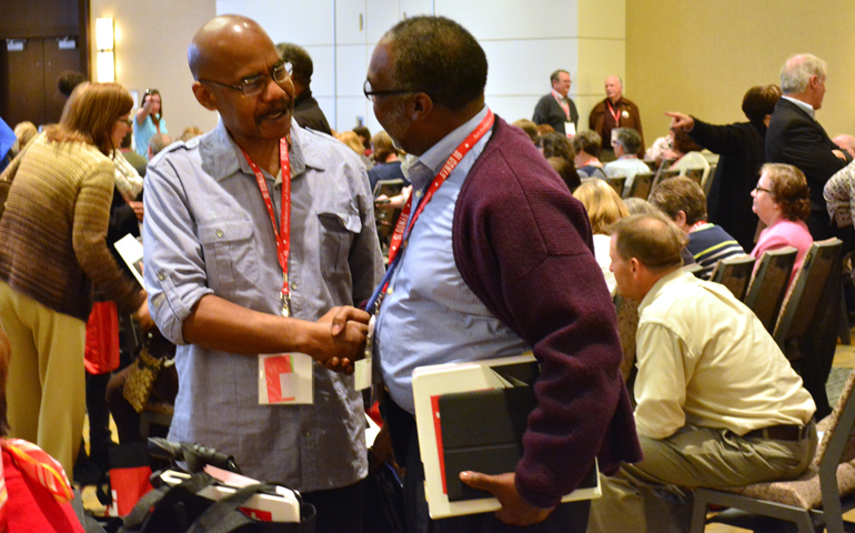 Synod members greet one another Nov. 18 during the opening session of the Detroit Archdiocese's synod. (CNS/Mike Stechschulte, The Michigan Catholic)