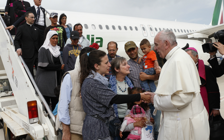 Pope Francis greets Syrian refugees he brought to Rome from the Greek island of Lesbos, at Ciampino airport in Rome April 16, 2016. The pope concluded his one-day visit to Greece by bringing 12 Syrian refugees to Italy aboard his flight. (CNS photo/Paul Haring)
